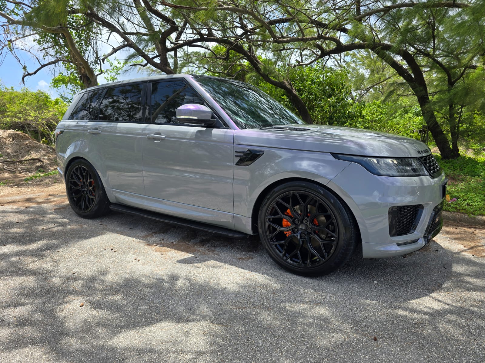 Silver Range Rover luxury chauffeur car beneath Barbados trees