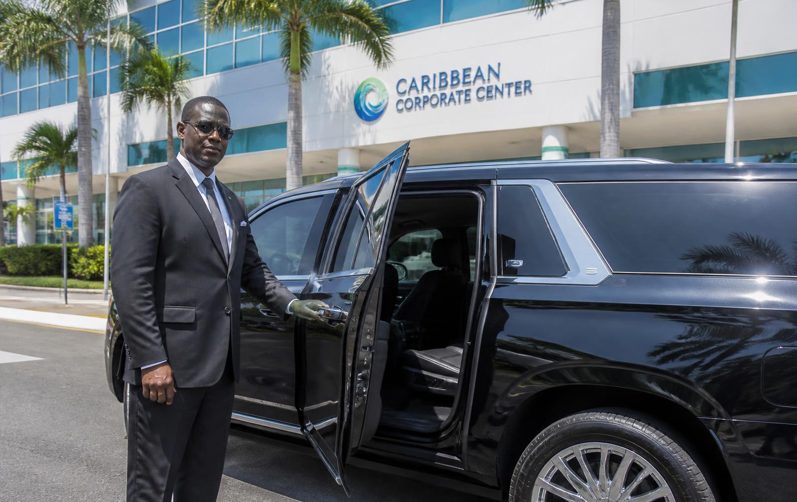 Chauffeur opening the door of an executive SUV in Barbados